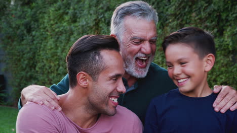 Portrait-Of-Multi-Generation-Male-Hispanic-Family-In-Garden-Smiling-At-Camera