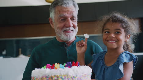 Granddaughter-Celebrates-Birthday-With-Grandfather-By-Putting-Cake-Cream-On-His-Nose-And-Laughing