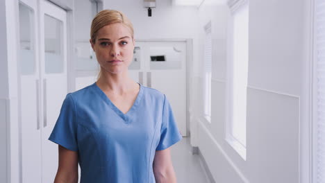 Portrait-Of-Female-Doctor-Wearing-Scrubs-In-Hospital-Corridor