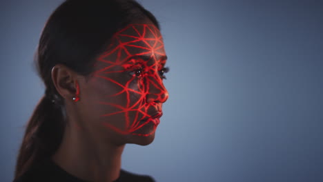Konzept-Der-Gesichtserkennungstechnologie,-Bei-Dem-Eine-Frau-Im-Studio-Ein-Rotes-Gitter-Auf-Ihr-Gesicht-Projiziert