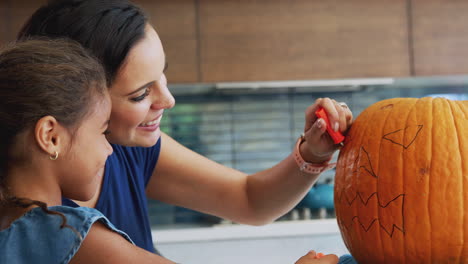 Mother-And-Daughter-Carving-Halloween-Lantern-From-Pumpkin-At-Home