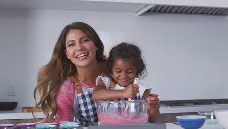 Portrait-Of-Hispanic-Mother-And-Daughter-Having-Fun-In-Kitchen-Baking-Cake-Together