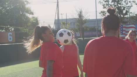 Player-Kicking-Ball-As-Female-Soccer-Team-Warm-Up-During-Training-Before-Match