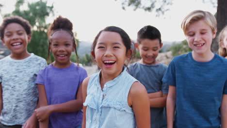 Portrait-Of-Multi-Cultural-Children-Hanging-Out-With-Laughing-Friends-In-Countryside-Together