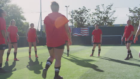 Spielerinnen-Kicken-Den-Ball,-Während-Sich-Die-Weibliche-Fußballmannschaft-Während-Des-Trainings-Vor-Dem-Spiel-Aufwärmt