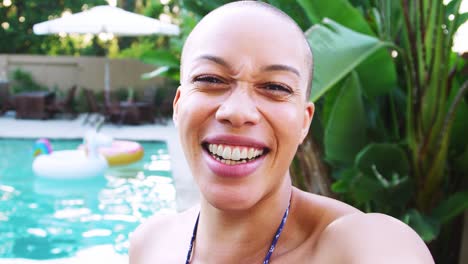 Portrait-Of-African-American-Woman-With-Shaved-Head-Outdoors-With-Friends-Enjoying-Summer-Pool-Party
