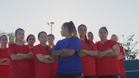 Retrato-De-Un-Determinado-Equipo-De-Fútbol-Femenino-Con-Entrenador-En-El-Campo-De-Entrenamiento-Contra-El-Sol-Abrasador