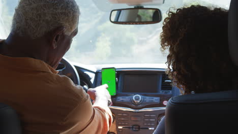 Älteres-Afroamerikanisches-Paar-Auf-Der-Fahrt-Durch-Die-Landschaft-Mit-Navigationsgerät-Auf-Dem-Mobiltelefon