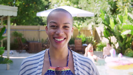 Portrait-Of-African-American-Woman-With-Shaved-Head-Outdoors-With-Friends-Enjoying-Summer-Pool-Party