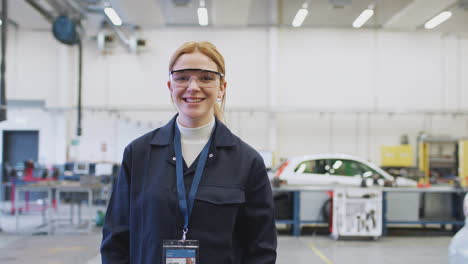 Portrait-Of-Female-Student-Wearing-Safety-Glasses-Studying-For-Auto-Mechanic-Apprenticeship