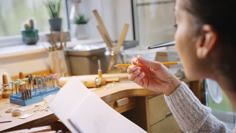 Close-Up-Of-Female-Jeweller-Sketching-Out-Design-For-Ring-In-Studio