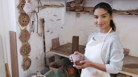 Portrait-Of-Young-African-American-Woman-Potter-Holding-Lump-Of-Clay-In-Ceramics-Studio