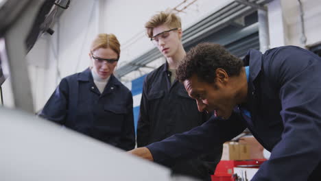Male-Tutor-With-Students-Looking-At-Car-Engine-On-Auto-Mechanic-Apprenticeship-Course-At-College