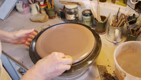 Nahaufnahme-Eines-Männlichen-Töpfers,-Der-Ton-Für-Ein-Hausschild-Auf-Einem-Töpferdrehteller-Im-Keramikatelier-Formt
