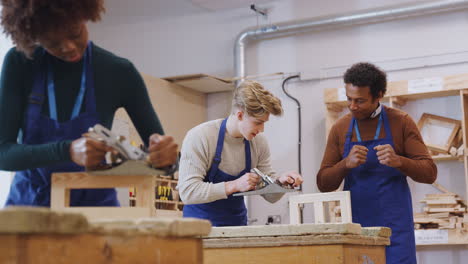 Tutor-With-Carpentry-Student-In-Workshop-Studying-For-Apprenticeship-At-College-Using-Wood-Plane