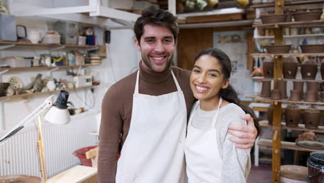 Portrait-Of-Young-Couple-Wearing-Aprons-Running-Pottery-And-Ceramics-Studio