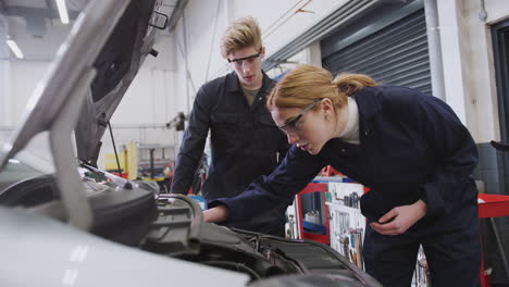 Male-And-Female-Students-Looking-At-Car-Engine-On-Auto-Mechanic-Apprenticeship-Course-At-College