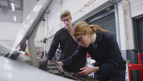 Male-And-Female-Students-Looking-At-Car-Engine-On-Auto-Mechanic-Apprenticeship-Course-At-College