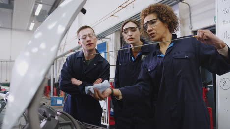 Female-Tutor-With-Students-Checking-Oil-Level-In-Car-Engine-On-Auto-Mechanic-Course-At-College