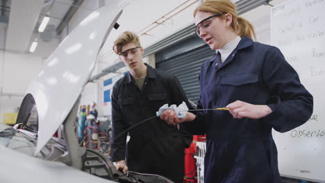 Male-And-Female-Students-Checking-Car-Oil-Level-On-Auto-Mechanic-Apprenticeship-Course-At-College