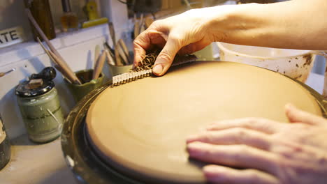 Nahaufnahme-Eines-Männlichen-Töpfers,-Der-Ton-Für-Ein-Hausschild-Auf-Einem-Töpferdrehteller-Im-Keramikatelier-Formt