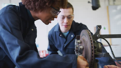 Tutor-With-Female-Students-Checking-Car-Brake-Discs-On-Auto-Mechanic-Course-At-College