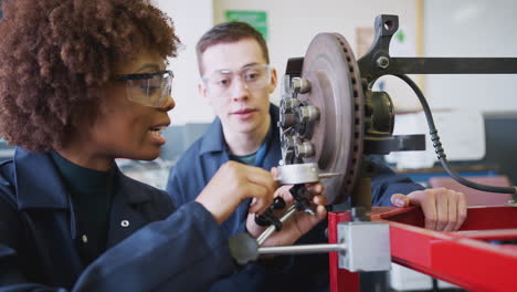Tutor-With-Female-Students-Checking-Car-Brake-Discs-On-Auto-Mechanic-Course-At-College