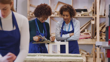 Tutor-With-Female-Carpentry-Student-In-Workshop-Studying-For-Apprenticeship-At-College