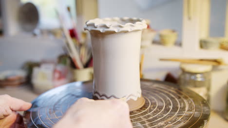 Close-Up-Of-Male-Potter-Putting-Design-In-Glaze-On-Clay-Vase-In-Ceramics-Studio