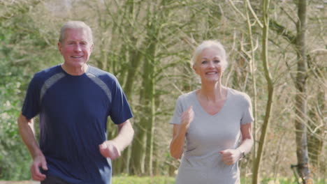 Senior-Couple-Running-In-Countryside-Exercising-During-Covid-19-Lockdown