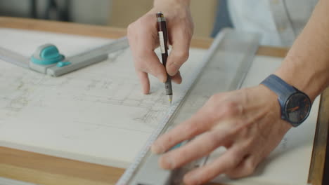 Der-Ingenieur-Zeichnet-Mit-Bleistift-Und-Lineal-Gebäude-Auf-Den-Tisch.-Ein-Architekt-Erstellt-Mit-Einem-Marker-Und-Einem-Lineal-Einen-Gebäudeentwurf-Auf-Papier.