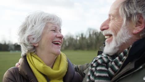 Lachendes-älteres-Paar,-Das-Gemeinsam-Den-Herbst--Oder-Winterspaziergang-Durch-Den-Park-Genießt