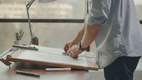 Concept-architectsengineer-holding-pen-pointing-equipment-architects-On-the-desk-with-a-blueprint-in-the-office-Vintage-Sunset-light.-Close-Up-Of-A-Draftsman-Drawing-Diagram-On-Blueprints