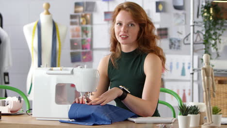 Portrait-Of-Female-Student-Or-Business-Owner-Working-In-Fashion-Industry-Using-Sewing-Machine