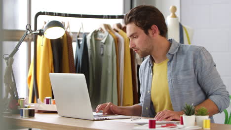 Male-Student-Or-Business-Owner-Working-In-Fashion-Using-Laptop-In-Studio