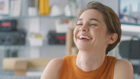 Close-Up-Of-Laughing-Businesswoman-In-Office-Working-At-Desk