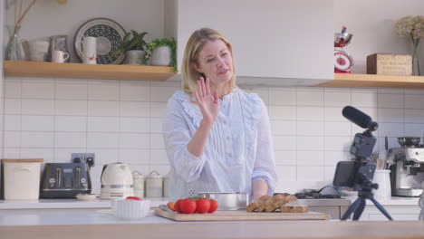 Frau-Vlogging-Und-Macht-Social-Media-Video-über-Essen-Zu-Hause-In-Der-Küche-Auf-Dem-Handy-–-Aufgenommen-In-Zeitlupe