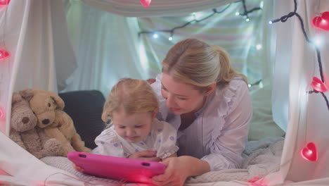 Mutter-Und-Kleine-Tochter-Mit-Digitalem-Tablet-Im-Selbstgebauten-Lager-Im-Kinderzimmer-Zu-Hause-–-Aufgenommen-In-Zeitlupe