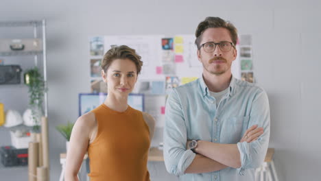 Portrait-Of-Male-And-Female-Architects-In-Office-Standing-By-Desks