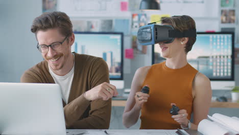 Architektin-Trägt-VR-Headset-Und-Hat-Spaß-Im-Büro-Bei-Der-Arbeit-Mit-Einem-Männlichen-Kollegen-Am-Laptop