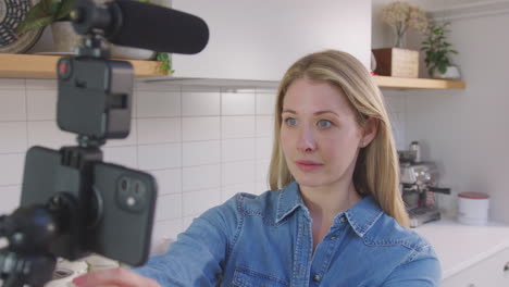 Point-of-view-shot-of-woman-vlogging-making-social-media-video-as-she-carries-camera-around-in-kitchen-at-home---shot-in-slow-motion