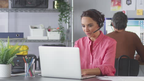 Businesswoman-Wearing-Telephone-Headset-Talking-To-Client-In-Customer-Services-Call-Centre