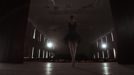 SLOW-MOTION:-Ballerina-dancing-in-Pointe-shoes-on-stage-in-smoke-in-the-dark-light-back-view.-the-camera-moves-on-gimbal