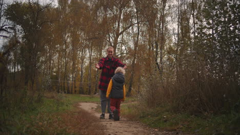 family-walk-in-forest-at-autumn-day-happy-little-boy-is-running-to-mother-woman-is-hugging-and-kissing-son-happy-and-loving-people-at-nature