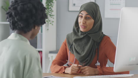 Female-Doctor-Or-Consultant-Wearing-Headscarf-Having-Meeting-With-Female-Patient-To-Discuss-Scans