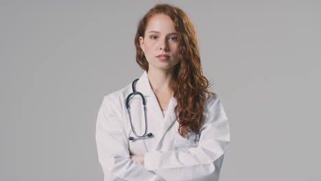 Studio-Portrait-Of-Serious-Female-Doctor-With-Stethoscope-In-White-Coat-Against-Plain-Background