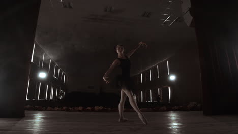 Eine-Anmutige-Ballerina,-Die-Ballettelemente-Im-Dunkeln-Tanzt,-Mit-Licht-Und-Rauch-Im-Hintergrund-In-Zeitlupe