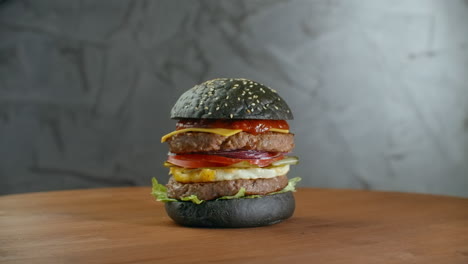 Schwarzer-Burger-Mit-Grünem-Gemüse.-Schwarzer-Burger-Auf-Holztisch