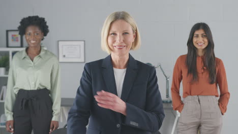 Portrait-Of-Smiling-Female-Multi-Racial-Business-Team-Standing-In-Office