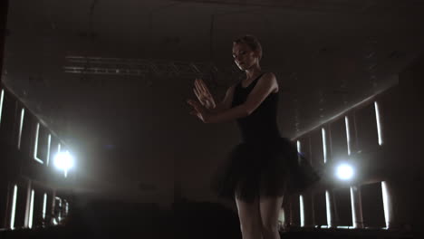Una-Elegante-Bailarina-Con-Un-Vestido-Oscuro-En-Un-Escenario-Oscuro-Del-Teatro-En-El-Humo-Realiza-Movimientos-De-Baile-En-Cámara-Lenta.